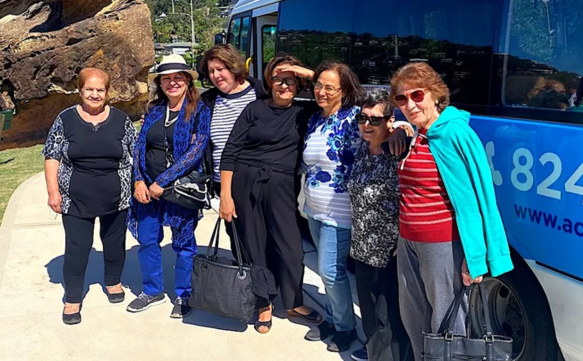 Group of clients standing next to a bus and smiling for the camera
